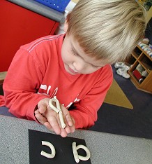 boy holding clay letter in his hand