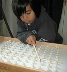 boy with grid of clay balls